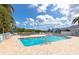 Community pool with brick paved patio, white fence, lounge chairs and tropical surroundings at 1316 Perico Point Cir, Bradenton, FL 34209