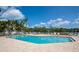 Community pool with brick paved patio, white fence, lounge chairs and tropical surroundings at 1316 Perico Point Cir, Bradenton, FL 34209