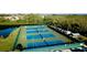 Aerial view of well-maintained tennis courts surrounded by lush landscaping and trees at 1316 Perico Point Cir, Bradenton, FL 34209