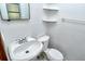Cozy half-bath featuring a sleek sink, toilet, and corner shelving at 1354 22Nd St, Sarasota, FL 34234