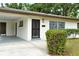 Close-up of the front of the house, highlighting the carport, decorative shrubs, and the secure, grilled front door at 1354 22Nd St, Sarasota, FL 34234