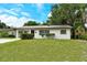 Inviting single-story home with a well-manicured lawn, mature trees, and a welcoming entrance at 1354 22Nd St, Sarasota, FL 34234