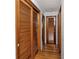 Hallway with wooden floor and wood-framed louvered doors to closets and rooms at 1354 22Nd St, Sarasota, FL 34234