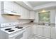 Clean kitchen featuring white cabinets, updated appliances, and a bright window overlooking the backyard at 1354 22Nd St, Sarasota, FL 34234