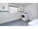 Laundry room featuring a modern washing machine, upper storage cabinets and a window at 1354 22Nd St, Sarasota, FL 34234