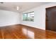 Cozy living room features gleaming hardwood floors, a ceiling fan, and a large window providing plenty of sunlight at 1354 22Nd St, Sarasota, FL 34234