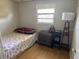 Modest bedroom with a single bed, nightstand, lamp, and a window with natural light at 1506 S 78Th S St, Tampa, FL 33619