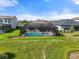 An aerial view showcasing a screened pool enclosure in a well-manicured backyard setting at 15316 Shady Palms Ln, Nokomis, FL 34275