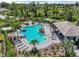 Aerial view of a community pool surrounded by lounge chairs, palm trees, and a shaded pergola at 15316 Shady Palms Ln, Nokomis, FL 34275