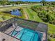 An aerial view of a screened pool and water feature with scenic water views in the backyard at 15316 Shady Palms Ln, Nokomis, FL 34275