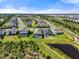 A scenic aerial view of a neighborhood with backyard pools, landscaping, and water features at 15316 Shady Palms Ln, Nokomis, FL 34275