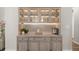 Chic bar area with glass-front cabinets, ambient lighting, and sleek countertops, ideal for entertaining at 15316 Shady Palms Ln, Nokomis, FL 34275