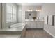 Elegant bathroom featuring a soaking tub, dual sinks, and modern finishes at 15316 Shady Palms Ln, Nokomis, FL 34275