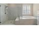 Bright bathroom featuring a soaking tub and glass enclosed shower at 15316 Shady Palms Ln, Nokomis, FL 34275