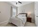 Cozy bedroom with plush carpeting, ceiling fan, and natural light from the window at 15316 Shady Palms Ln, Nokomis, FL 34275