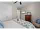 This bedroom features a decorative chair, large double closets and neutral paint at 15316 Shady Palms Ln, Nokomis, FL 34275