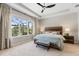 Bright bedroom with a large window, tray ceiling, neutral decor, and plush carpeting at 15316 Shady Palms Ln, Nokomis, FL 34275