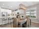 Bright dining room with woven chairs, pendant lighting, and an adjacent kitchen with island seating at 15316 Shady Palms Ln, Nokomis, FL 34275