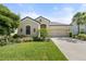 Well maintained single-story home featuring a manicured lawn, two-car garage, and beautiful landscaping at 15316 Shady Palms Ln, Nokomis, FL 34275