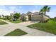 A well-maintained single-Gathering home with a spacious driveway, lush landscaping, and a two-car garage at 15316 Shady Palms Ln, Nokomis, FL 34275