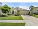 A charming single-Gathering home featuring manicured landscaping, lawn, and a two-car garage at 15316 Shady Palms Ln, Nokomis, FL 34275