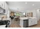 Modern kitchen features white cabinets, stainless steel appliances, and an open concept design to the living area at 15316 Shady Palms Ln, Nokomis, FL 34275
