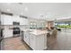 Open concept kitchen featuring white cabinets, quartz countertops, and stainless steel appliances at 15316 Shady Palms Ln, Nokomis, FL 34275
