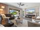 Open living area features a comfortable leather sectional, tile flooring, TV, and access to the outdoor living space at 15316 Shady Palms Ln, Nokomis, FL 34275