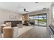 Spacious living room features a comfortable leather sectional, tile floors, and access to the outdoor pool area at 15316 Shady Palms Ln, Nokomis, FL 34275