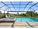 Relaxing screened-in pool area with a connected spa and a view of the open landscape at 15316 Shady Palms Ln, Nokomis, FL 34275