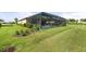 An inviting screened pool area with lush greenery and a well-maintained lawn at 15316 Shady Palms Ln, Nokomis, FL 34275