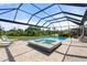 Resort-style pool area with a spa, sun loungers, and a screened enclosure at 15316 Shady Palms Ln, Nokomis, FL 34275