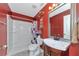 Red bathroom showcasing a white shower and a vanity with a sink and chrome faucet at 15440 County Road 675, Parrish, FL 34219