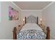 Cozy bedroom with ornate wrought iron bed frame, textured ceilings, and floral art at 15440 County Road 675, Parrish, FL 34219