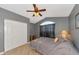 Cozy bedroom with gray walls, vaulted ceiling, tiled floor, and a sunny window with dark curtains at 15440 County Road 675, Parrish, FL 34219