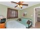 Second bedroom with a futon, twin bed, 2 windows with dark curtains and a ceiling fan with lights at 15440 County Road 675, Parrish, FL 34219