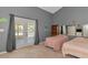 Bedroom with two beds, neutral carpet, gray walls, and French doors opening to the outside at 15440 County Road 675, Parrish, FL 34219
