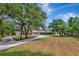 Expansive front yard with mature trees and a long driveway leading to a well-maintained home at 15440 County Road 675, Parrish, FL 34219