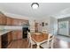 Kitchen with a cozy dining table, wooden cabinets, appliances, and access to an adjacent room at 15440 County Road 675, Parrish, FL 34219