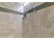Modern shower features gray stone tile with decorative accent tiles, and brushed metal shower head at 15440 County Road 675, Parrish, FL 34219
