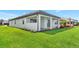 Back of the house has a covered patio, lush green lawn, and beautiful landscaping at 17333 Savory Mist Cir, Bradenton, FL 34211