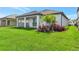 Expansive backyard featuring well-manicured lawn, lush landscaping and a covered patio with brick pavers at 17333 Savory Mist Cir, Bradenton, FL 34211