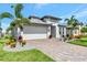 Beautiful single-Gathering home featuring lush landscaping, a paver driveway, and a two-car garage at 17333 Savory Mist Cir, Bradenton, FL 34211