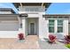 Charming home features a welcoming entryway with lush landscaping, a gray front door, and a two-car garage at 17333 Savory Mist Cir, Bradenton, FL 34211