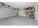 Spacious two-car garage with epoxy flooring, overhead storage racks, and ample room for parking and storage at 17333 Savory Mist Cir, Bradenton, FL 34211