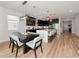 Open concept kitchen with a waterfall island, stainless steel appliances, dark cabinets, and a dining area at 17333 Savory Mist Cir, Bradenton, FL 34211