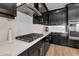 A kitchen with a cooktop, stainless appliances, and white backsplash at 17333 Savory Mist Cir, Bradenton, FL 34211