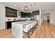 Spacious kitchen featuring an island with seating, dark cabinets, stainless steel appliances, and modern pendant lighting at 17333 Savory Mist Cir, Bradenton, FL 34211