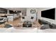 Open-concept living room and kitchen area with modern decor, hardwood floors, and stainless steel appliances at 17333 Savory Mist Cir, Bradenton, FL 34211