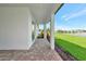 Covered patio with brick pavers, overlooking a well-maintained lawn and serene lake views at 17333 Savory Mist Cir, Bradenton, FL 34211